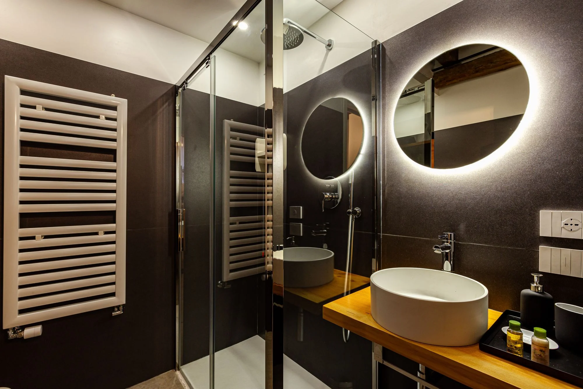 En-suite bathroom with walk-in shower and backlit oval mirrors