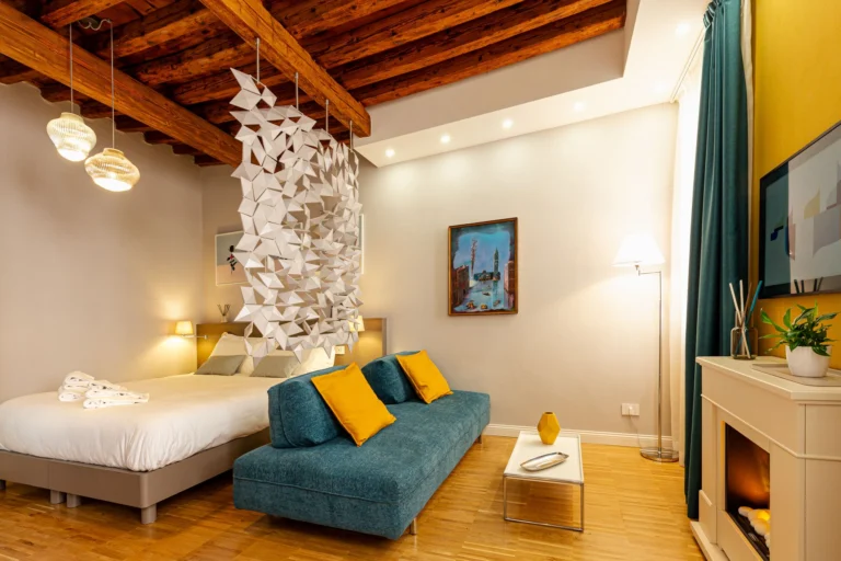 Teal sofa with yellow cushions next to the bed in the second bedroom