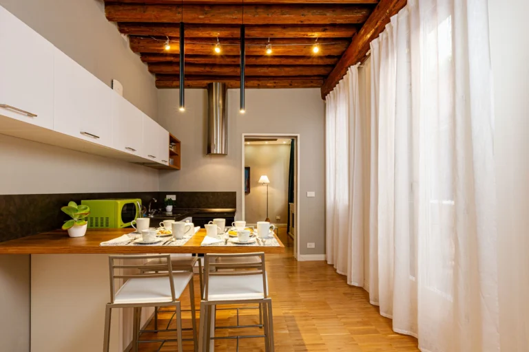 Breakfast bar and kitchen under the beamed ceiling, with sheer curtains