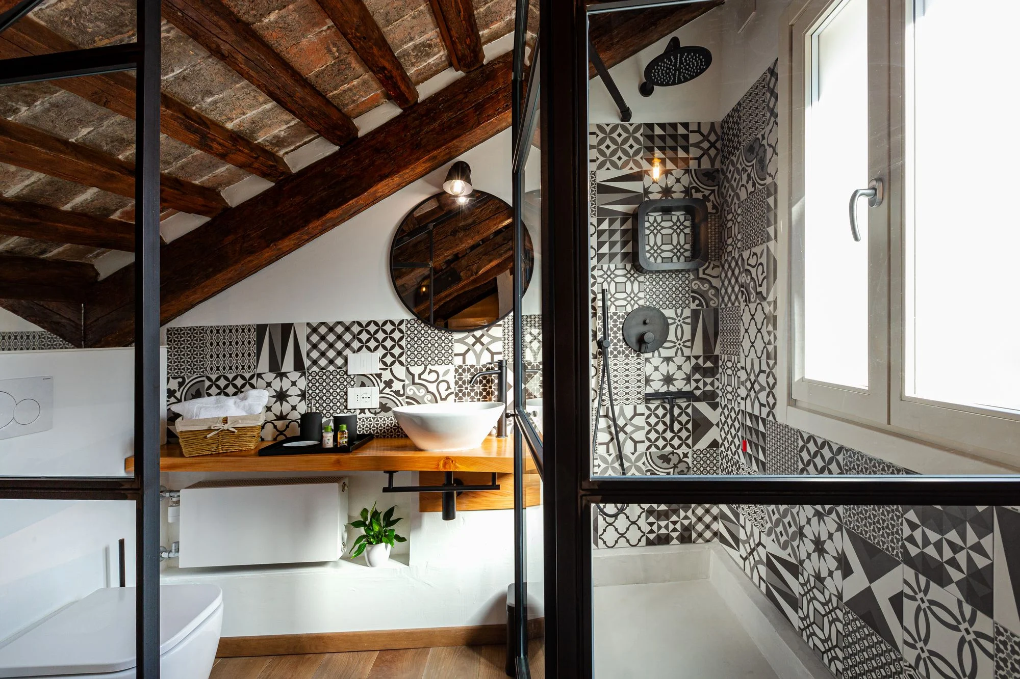 The room's bathroom with patterned tiles and large shower